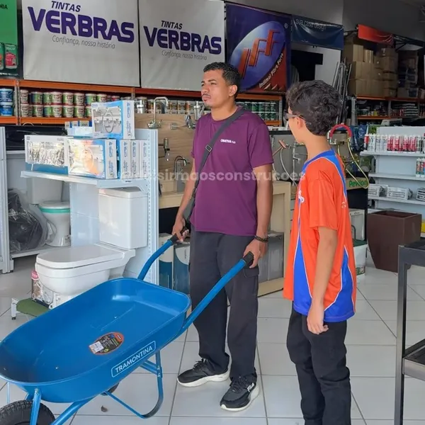 Cliente conferindo um carrinho de mão dentro da Dois Irmãos Construções